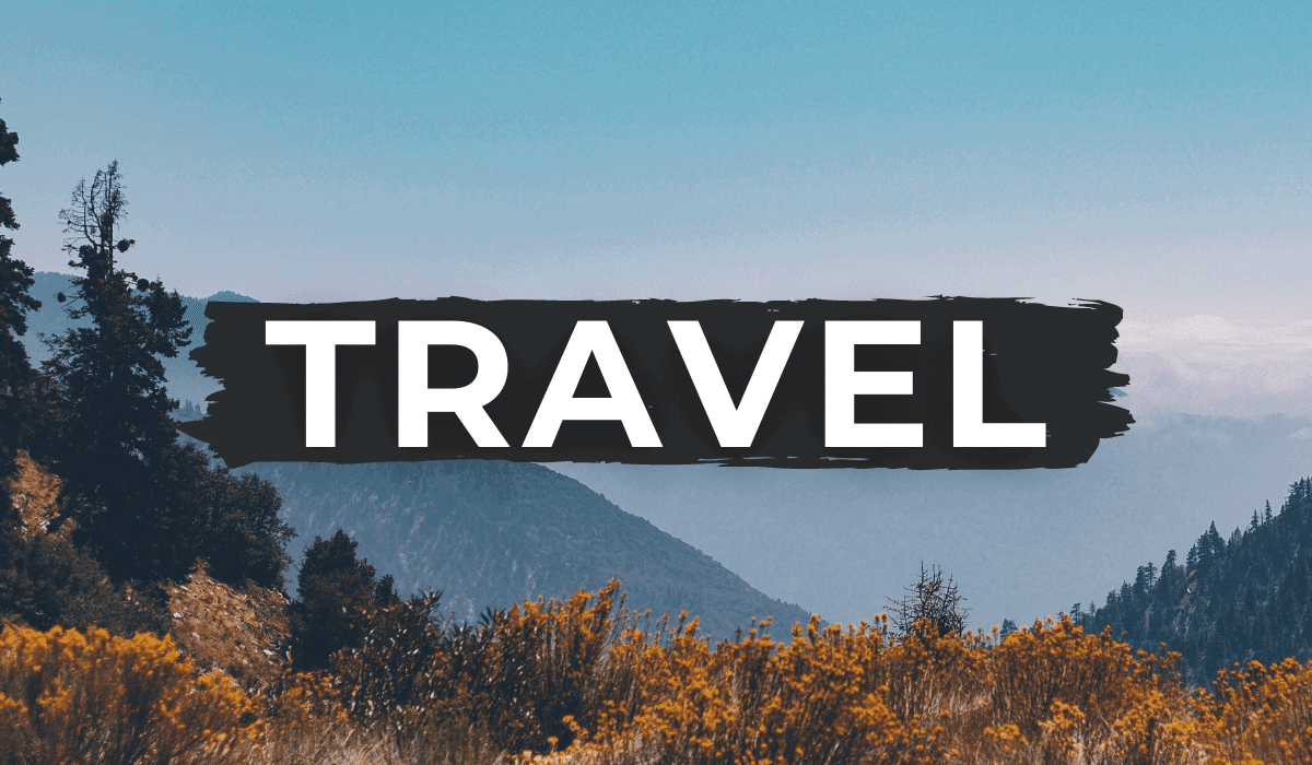 mountains & fall foilage in the foreground with the word "TRAVEL" written in white across the photo