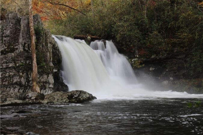 wide waterfall among autumn trees